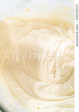 In a large mixing bowl, the ingredients are expertly mixed to create a delectable cream cheese buttercream for the Carrot Bundt Cake. In a large mixing bowl, the ingredients are expertly mixed to create a delectable cream cheese buttercream for the Carrot Bundt Cake. 109338321