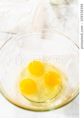 With a hand whisk, the measured ingredients come together - expertly mixed to prepare the cake batter for this delightful bundt cake. 109338394