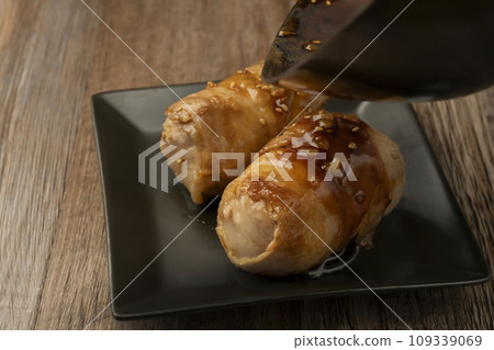 Grill meat-wrapped rice balls and sprinkle with sauce 109339069