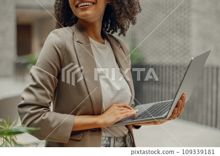 Close up of female manager holding laptop and looking at side while standing in modern coworking 109339181