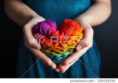 Hands hold heart in the colors of rainbow on light blue background. LGBT concept. Generative AI 109339334