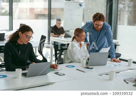 Business people working with laptops in office on colleagues background. Teamwork concept Business people working with laptops in office on colleagues background. Teamwork concept 109339532