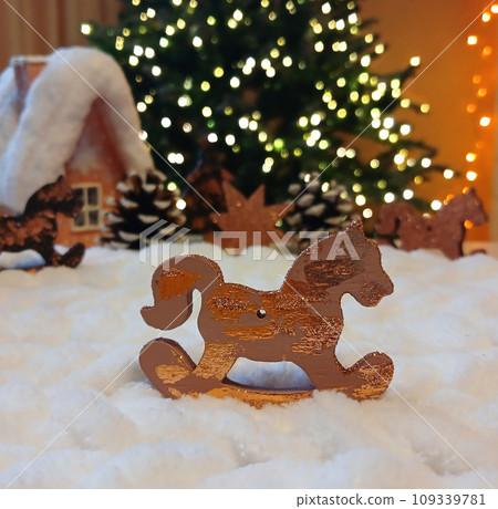 a wooden toy horse on the background of a luminous garland a wooden toy horse on the background of a luminous garland 109339781
