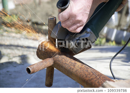 male hands hold a working power tool for cutting metal 109339786