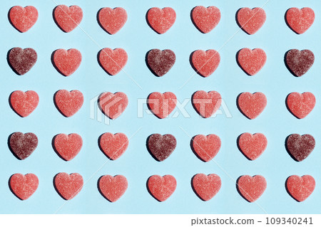 Pattern of gummy vitamin candy in shape of heart on blue background. Concept. 109340241