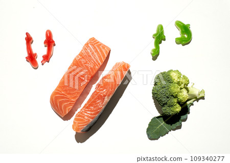 Gummy vitamins candy in shape of sharks and raw salmon fish and broccoli Gummy vitamins candy in shape of sharks and raw salmon fish and broccoli 109340277