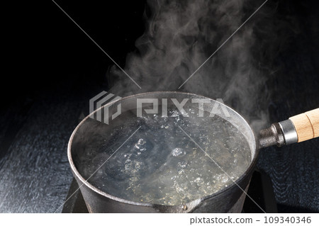Scene of boiling water in an iron pot Scene of boiling water in an iron pot 109340346