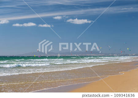 Kiteboarding kitesurfing kiteboarder kitesurfer kites on the Atlantic ocean beach at Fonte da Telha beach, Costa da Caparica, Portugal Kiteboarding kitesurfing kiteboarder kitesurfer kites on the Atlantic ocean beach at Fonte da Telha beach, Costa da Caparica, Portugal 109341636