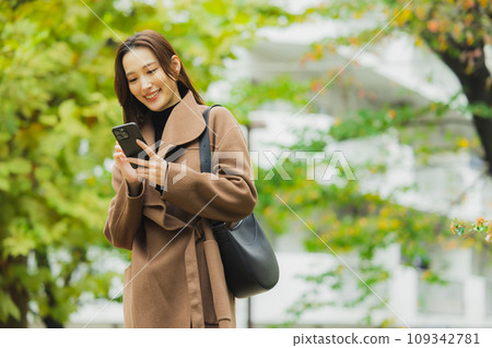 穿著外套在戶外散步的女人 穿著外套在戶外散步的女人 109342781