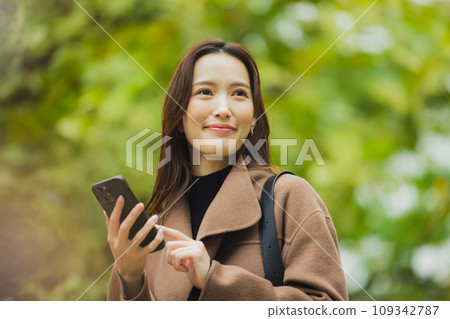 A woman in a coat walking outdoors A woman in a coat walking outdoors 109342787