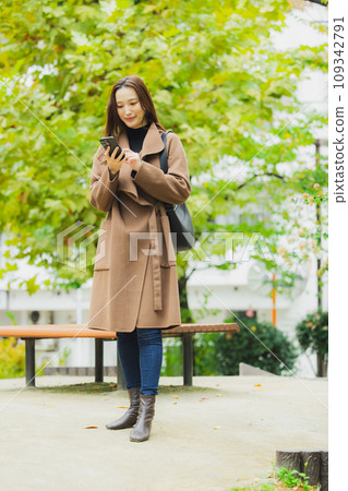 A woman in a coat walking outdoors A woman in a coat walking outdoors 109342791