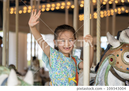 一個女孩騎著旋轉木馬玩得很開心 一個女孩騎著旋轉木馬玩得很開心 109343004