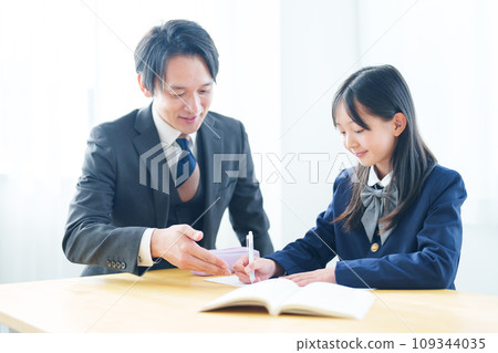 teacher teaching a girl to study 109344035
