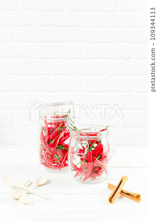 Spices seasoning chili pepper in glass bottle and cinnamon on table 109344113