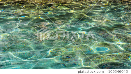 Emerald sea water in sunshine glow as surface background. Summer holidays concept 109346043