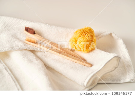 Two toothbrushes on a terry towel and a natural sponge. Two toothbrushes on a terry towel and a natural sponge. 109346177