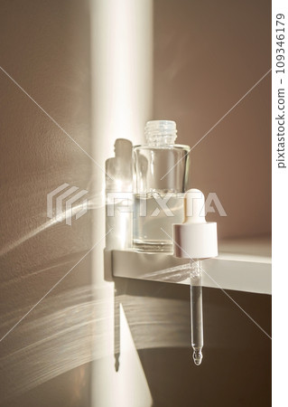 A transparent bottle of serum under the morning sun. 109346179