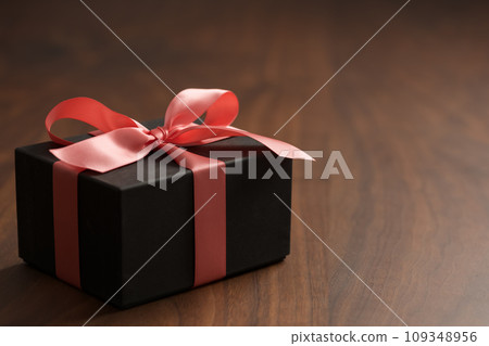 paper gift box with ribbon on walnut wood table with copy space paper gift box with ribbon on walnut wood table with copy space 109348956