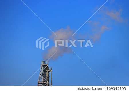 Pipe with white smoke against a blue sky. 109349103
