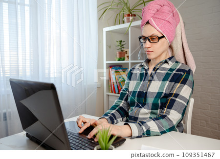 Woman with pink towel on head is working remotely from home Woman with pink towel on head is working remotely from home 109351467