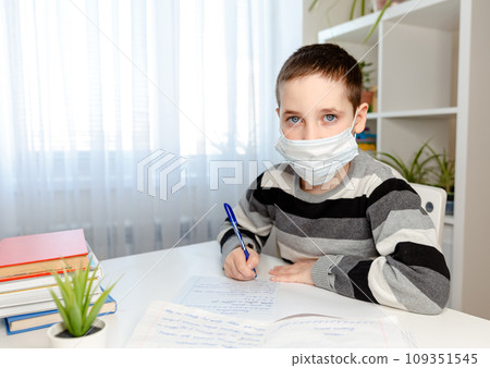 Sickness boy in medical mask studying at home and doing homework 109351545
