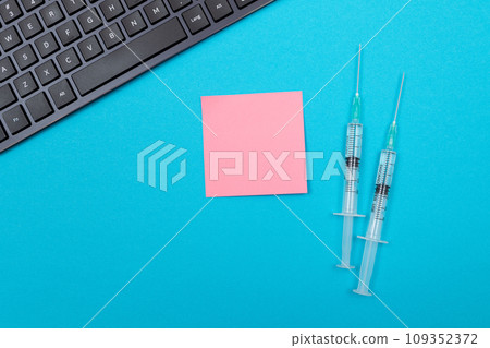 Vaccination or Revaccination Concept - Two Medical Syringe on Blue Table Vaccination or Revaccination Concept - Two Medical Syringe on Blue Table 109352372