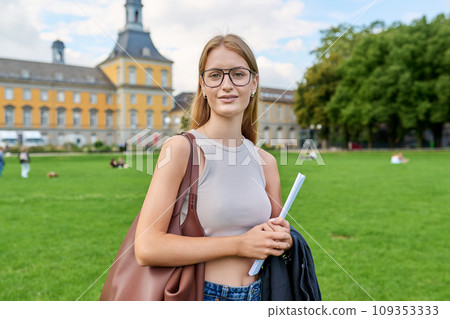 Young girl student posing outdoors, background of educational building 109353333