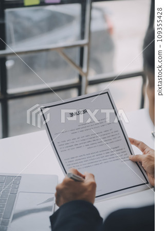 Close up view of job interview in office, focus on resume writing tips, employer reviewing good cv of prepared skilled applicant, recruiter considering application, hr manager making hiring decision Close up view of job interview in office, focus on resume writing tips, employer reviewing good cv of prepared skilled applicant, recruiter considering application, hr manager making hiring decision 109355428