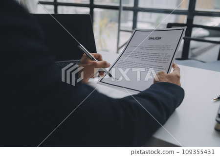 Close up view of job interview in office, focus on resume writing tips, employer reviewing good cv of prepared skilled applicant, recruiter considering application, hr manager making hiring decision Close up view of job interview in office, focus on resume writing tips, employer reviewing good cv of prepared skilled applicant, recruiter considering application, hr manager making hiring decision 109355431