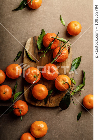 Mandarin oranges, clementines or tangerines with leaves on a dark background, top view 109355794