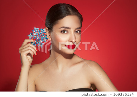 Beautiful young woman with glowing snowflake 109356154