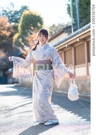 Smiling young woman wearing a kimono 109356704