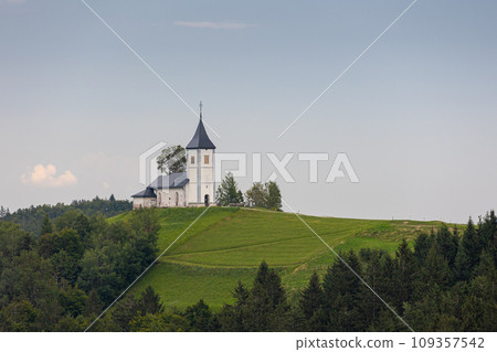 Jamnik, Slovenia. The Jamnik Church is a charming 15th-century chapel in the Kamnik-Savinja Alps near Kranj, breathtaking views of the surrounding mountainous landscape. The Church of St. Primoz Jamnik, Slovenia. The Jamnik Church is a charming 15th-century chapel in the Kamnik-Savinja Alps near Kranj, breathtaking views of the surrounding mountainous landscape. The Church of St. Primoz 109357542