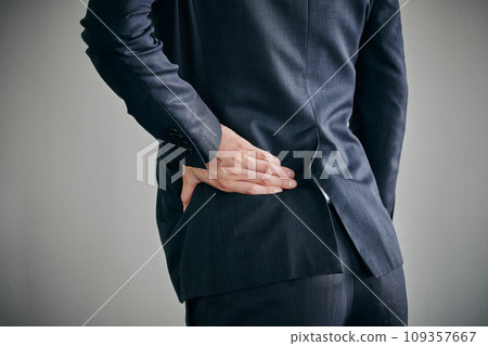 一名年輕男性上班族腰部疼痛，用手按住。 109357667