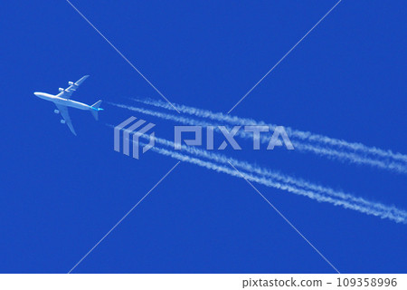 Jumbo jet flying in the blue sky and contrail 109358996