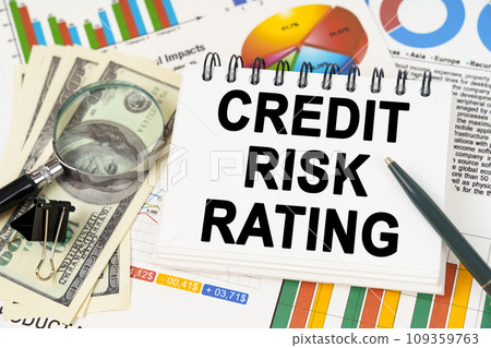On the table are business charts, dollars and a notepad with the inscription - Credit risk rating On the table are business charts, dollars and a notepad with the inscription - Credit risk rating 109359763