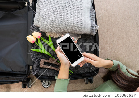 Happy Woman using smartphone booking vacation at travel agency or making hotel reservation online 109360637