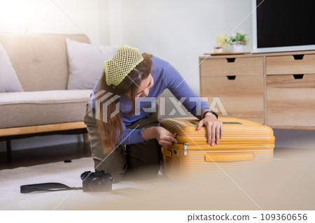 Woman packing a suitcase for a new travel trip. bag and luggage for journey Woman packing a suitcase for a new travel trip. bag and luggage for journey 109360656