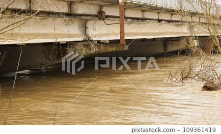 Critical water level in the river. Flooding. Water rose to the top of a car bridge. Natural disaster, extreme weather conditions. Weather cataclysm. The problem of global warming. Critical water level in the river. Flooding. Water rose to the top of a car bridge. Natural disaster, extreme weather conditions. Weather cataclysm. The problem of global warming. 109361419