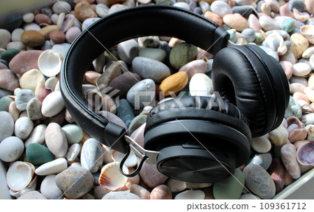 Modern Headphones On A Smooth Sea Rocks And Shells Angle View Modern Headphones On A Smooth Sea Rocks And Shells Angle View 109361712