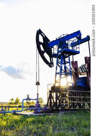 An active oil rig operating at sunrise or sunset. Resource extraction, oil crisis. 109361905