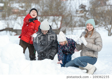 Boys and girls are playing in snowballs. Active outdoors leisure with family with children in winter. Winter holidays Boys and girls are playing in snowballs. Active outdoors leisure with family with children in winter. Winter holidays 109362235