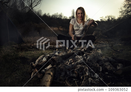 A girl cuts wood for a fire at a picnic. High quality photo 109363052