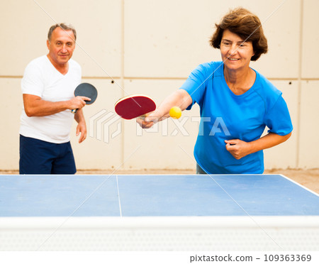Mature couple playing ping pong outdoors at outdoor 109363369