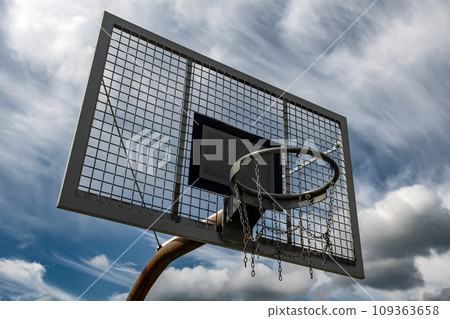 Metal Basketball Board And Ring With Chains In Front Of Sky With Heavy Clouds Metal Basketball Board And Ring With Chains In Front Of Sky With Heavy Clouds 109363658