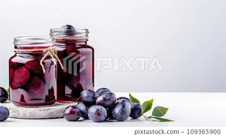Homemade compote in large glass jars sweet compote from plums. Two jars of homemade compote on white background. Homemade compote in large glass jars sweet compote from plums. Two jars of homemade compote on white background. 109365900