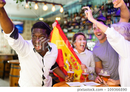 Joyful fans of the Spain team celebrating the victory in night bar Joyful fans of the Spain team celebrating the victory in night bar 109366890