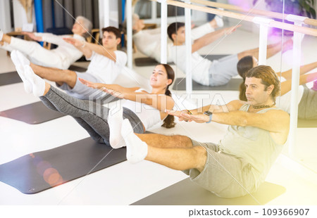 Group of different people doing exercises in gym Group of different people doing exercises in gym 109366907