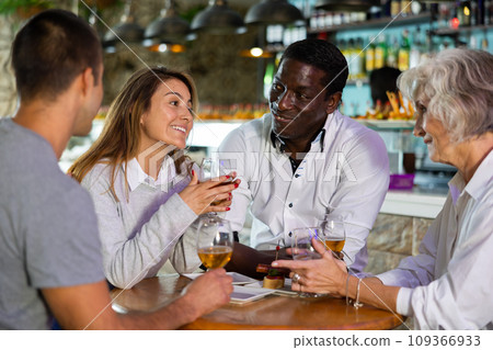 People talking and toasting in pub with the beers 109366933