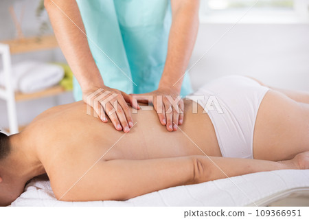 Close up male manual worker doing spa massage to young girl in room 109366951
